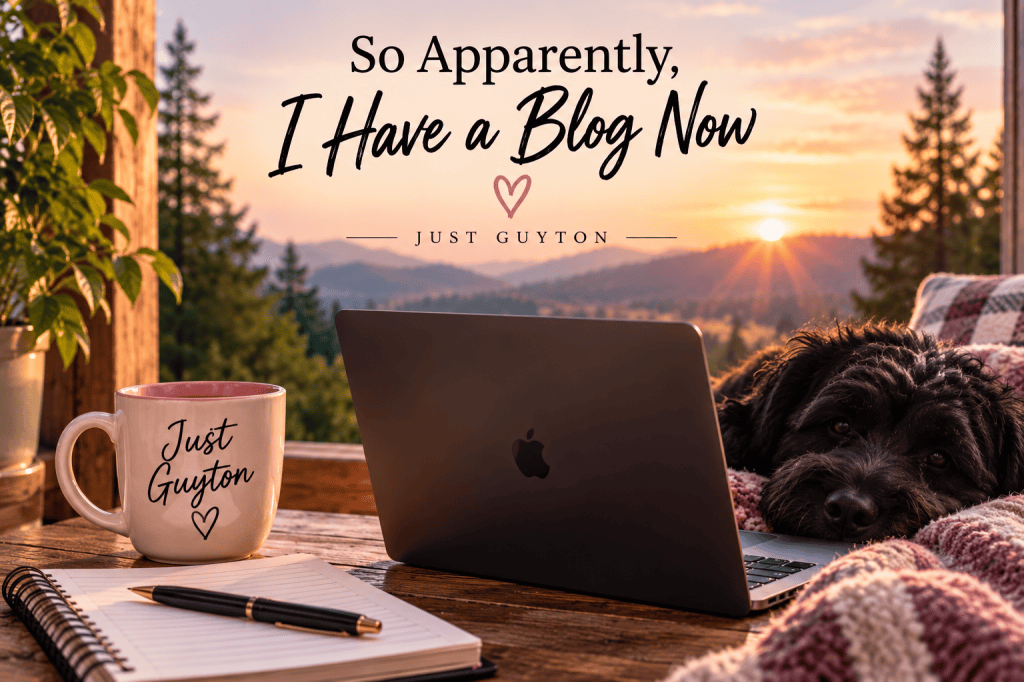Cozy Just Guyton writing setup with a coffee mug, notebook, laptop, and fluffy black dog overlooking a mountain sunrise, featuring the words “So Apparently, I Have a Blog Now.”